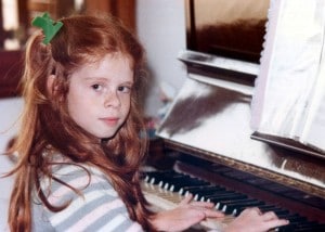 Fernanda ao piano com 8 anos